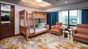 A bunk bed with a ladder, a sofa, a small table, and a large window with curtains.