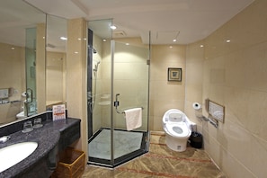 A modern bathroom with a glass-enclosed shower, a separate toilet, and a large mirror. - Jiangmen Gladden Hotel (Jiangmen)