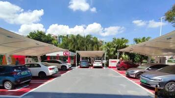 A gas station with multiple fuel pumps and cars parked.