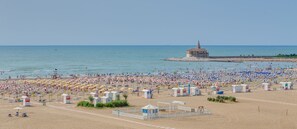 A beach with numerous umbrellas and beach huts. - Hotel Serena (Caorle)