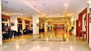 A hotel lobby with a reception desk, seating area, and a large potted plant. - Miarosa Konaklı Garden - All Inclusive (Alanya)