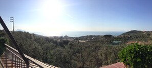 A view from a balcony overlooking a valley with a clear sky and distant mountains. - Terrazza Iride (Massa Lubrense)