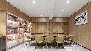 A conference room with a long table, six chairs, and a bookshelf with books and signs. - HanTing Hotel (Beijing Changhong Bridge Tuanjiehu Subway Station) (Beijing)