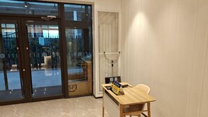 A hotel lobby with a reception desk, a glass door entrance, and a view of the outside. - HanTing Hotel (Beijing Changhong Bridge Tuanjiehu Subway Station) (Beijing)