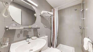 A modern bathroom with a sink, mirror, towel rack, shower, and bathtub. - Crystal Hotel (Levallois-Perret)