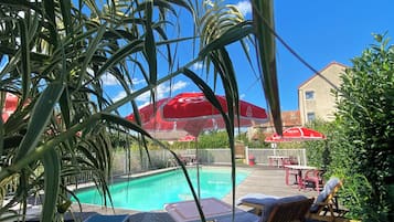 Piscine extérieure, parasols de plage, chaises longues