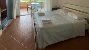A hotel room with a bed, a desk, a chair, and a view of the outdoors. - Jonio Vacanze Residence (Castellaneta)