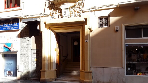 A building entrance with a staircase leading to an upper floor. - Fan Rooms Duquesa (Málaga)