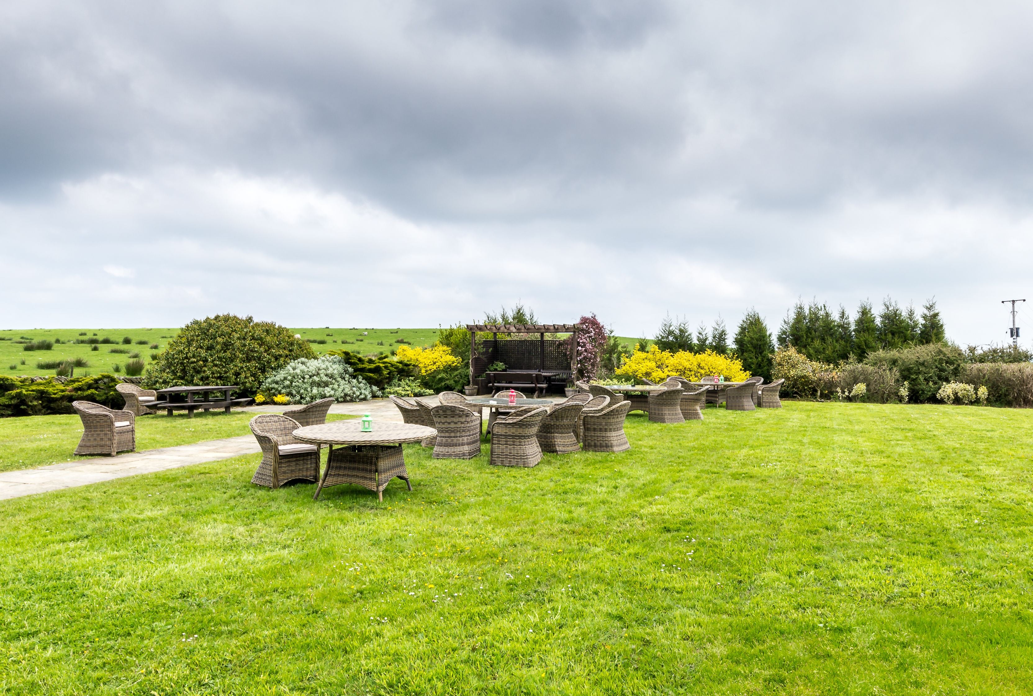 An outdoor patio area with wicker furniture and a barbecue grill.