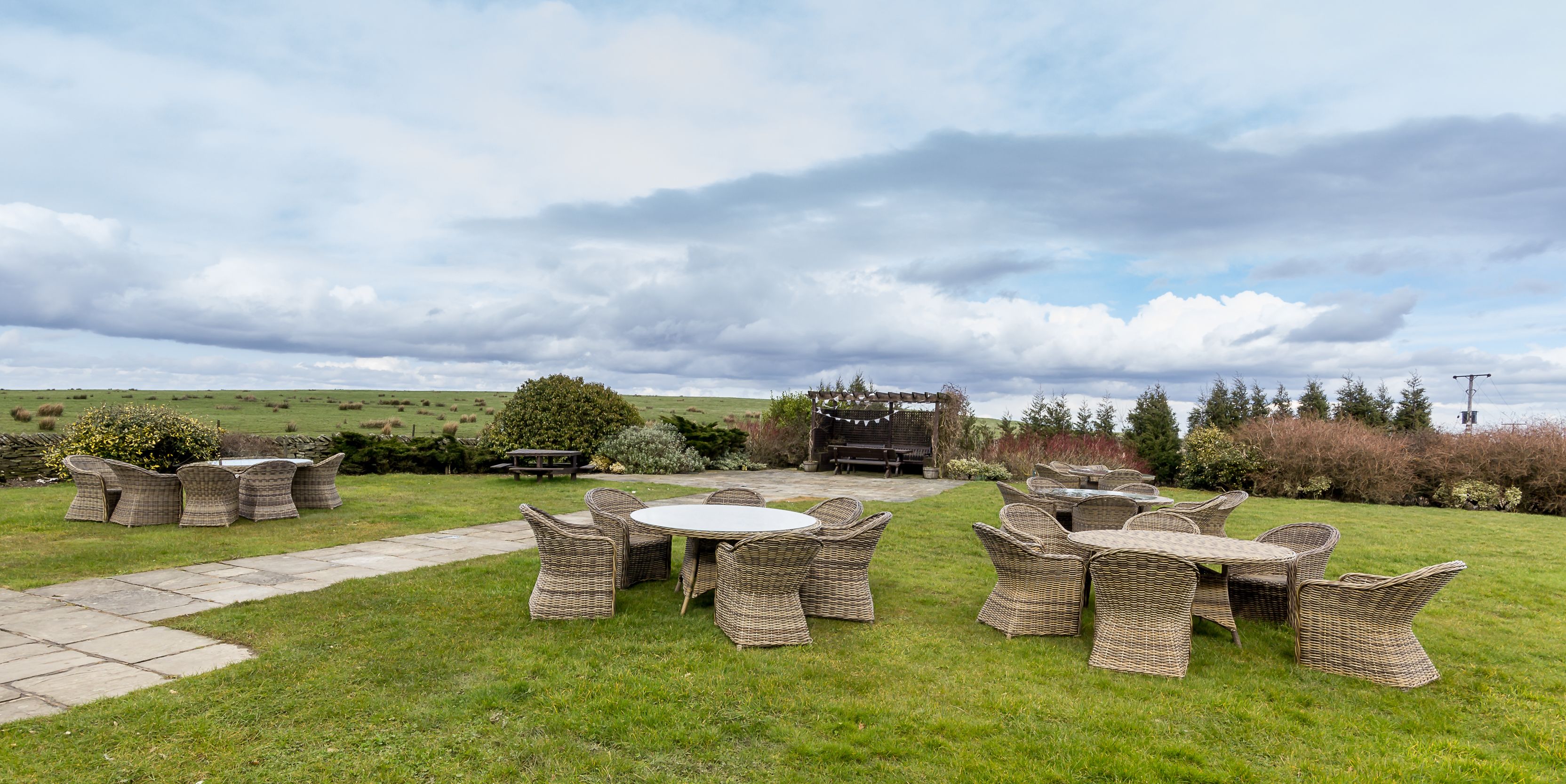 An outdoor seating area with wicker furniture and a stone pathway.
