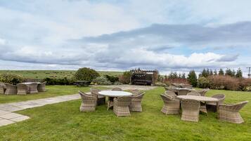 An outdoor seating area with wicker furniture and a stone pathway.