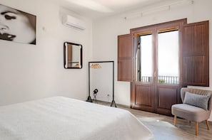 A bedroom with a bed, a chair, a wardrobe, a mirror, and a window. - Etnella enoagriturismo Notti Stellate (Mascali)