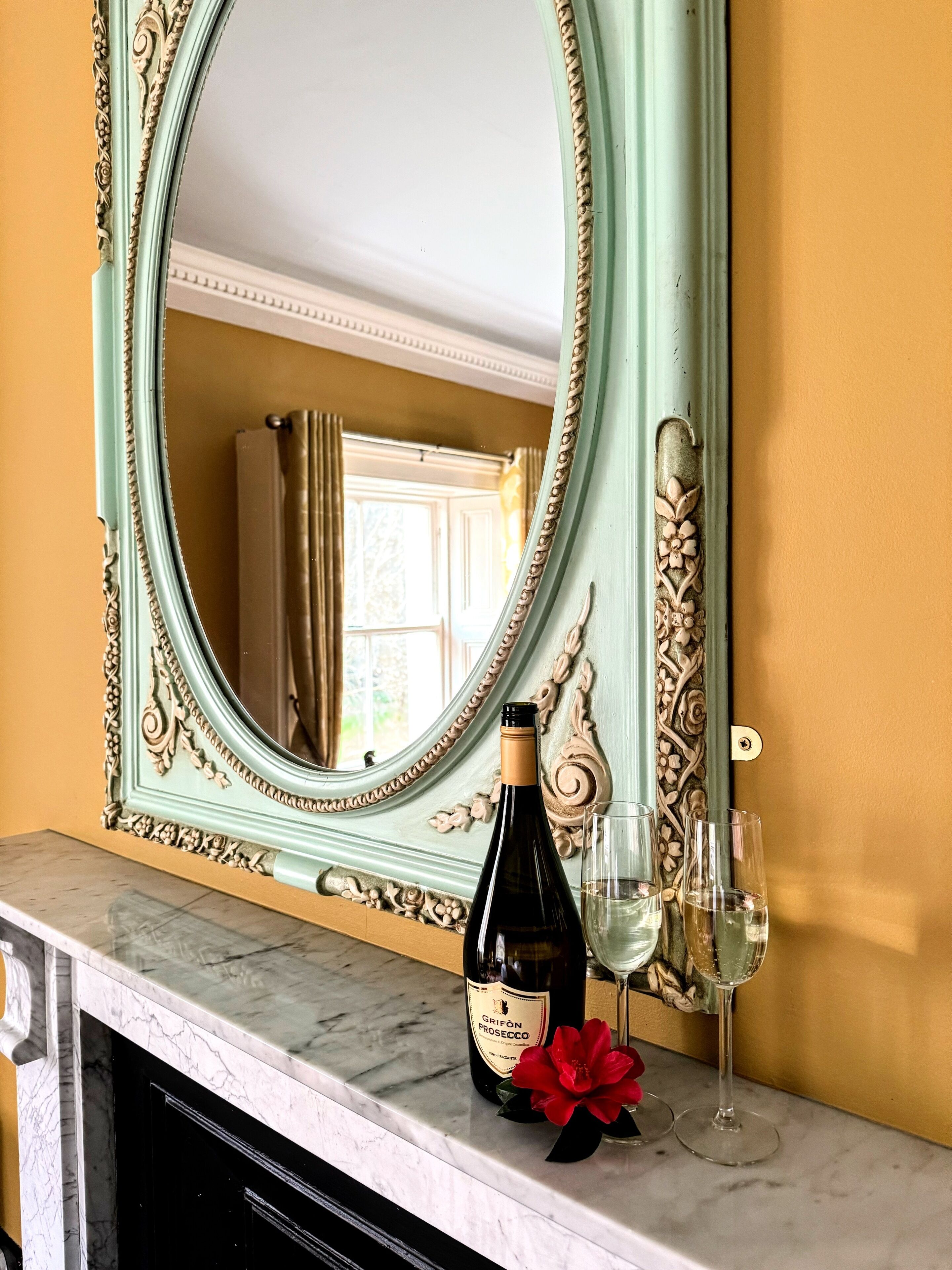 A marble countertop with a wine bottle and two glasses.