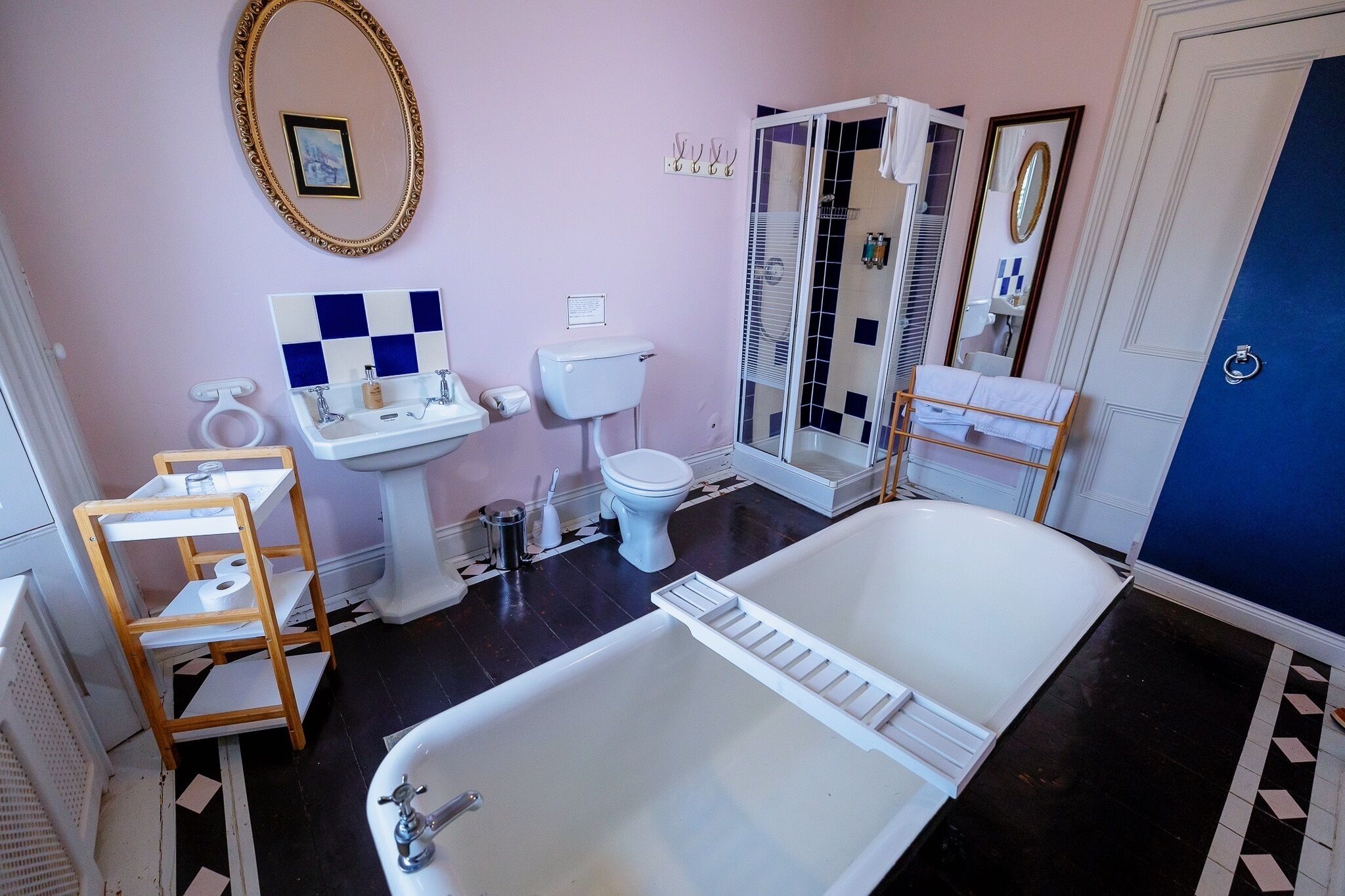 A bathroom with a bathtub, toilet, sink, and a shower area.