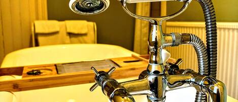 A bathroom with a white sink, chrome faucet, and a showerhead.
