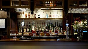 A bar area with multiple bottles and a beer tap. - The Golden Pheasant (Knutsford)