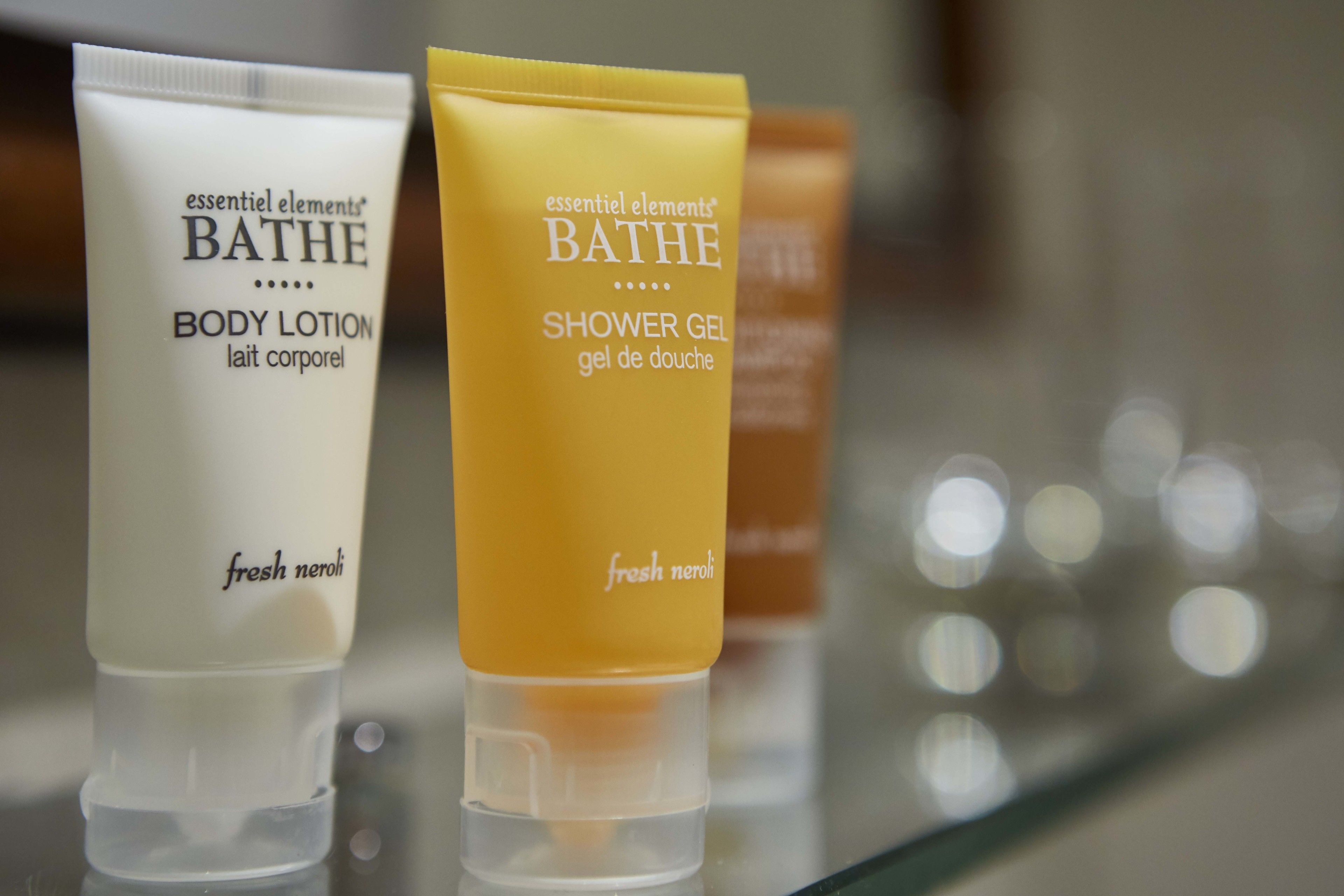 Two bottles of 'essential elements' bath products, one labeled 'body lotion' and the other 'shower gel'.