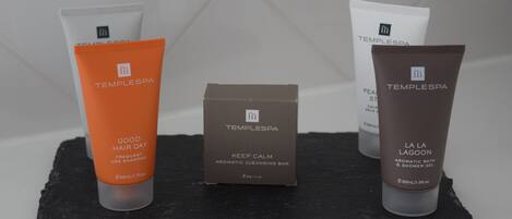 Three toiletries on a black slate surface.