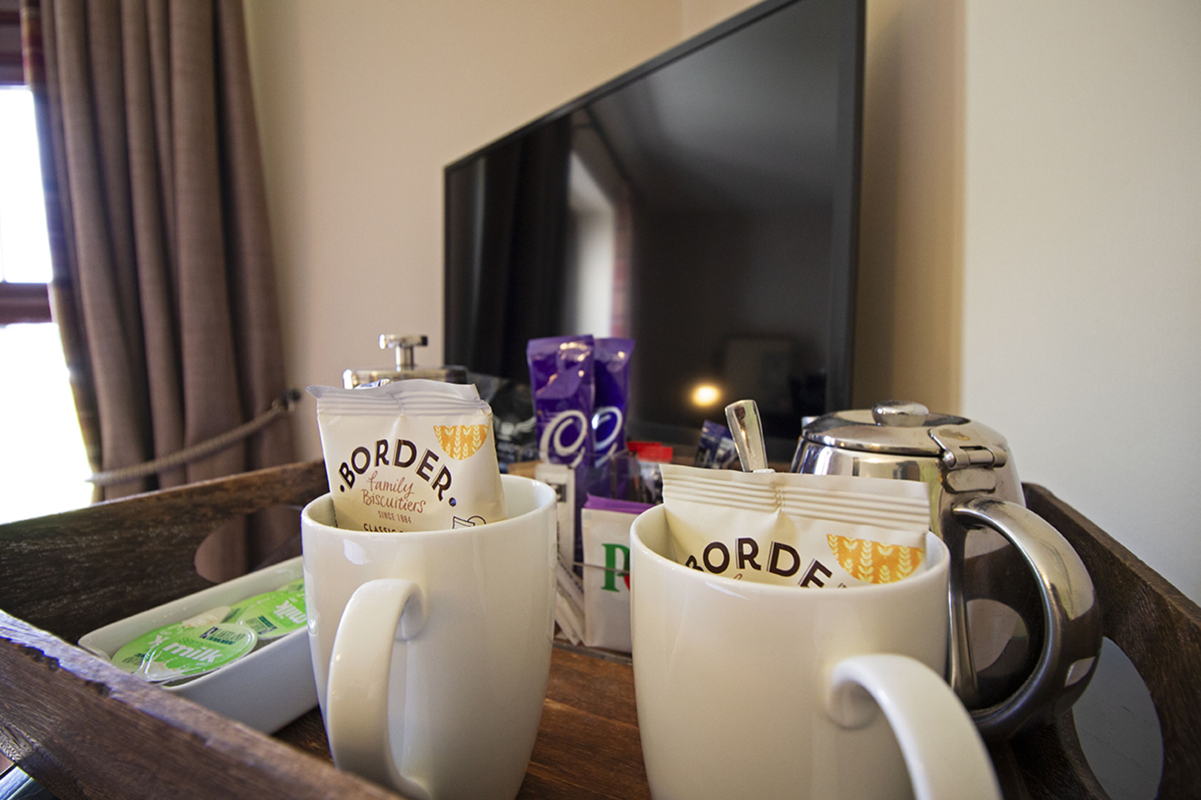A tray with two white mugs labeled 'BORDEAU' and a silver coffee pot.