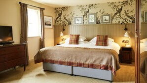 A hotel room with a large bed, a TV, a dresser, and a window with curtains. - The Groes Inn (Conwy)