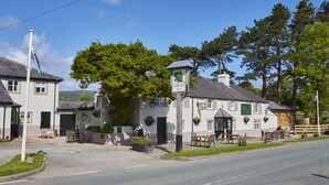 A traditional building with a sign reading "Groes Inn," featuring a welcoming entrance, outdoor seating, and a flagpole. - The Groes Inn (Conwy)