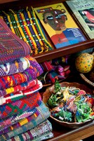Una exhibición de textiles coloridos tejidos y un cuenco con objetos de diseños intrincados.
