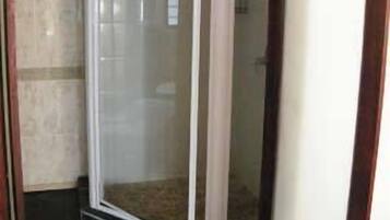 Une pièce d’angle avec une cloison en verre, un sol carrelé et une fenêtre bien visible.