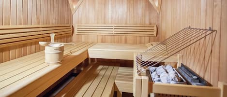 A sauna with wooden benches and a bench with a towel rack.