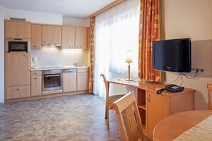 A compact hotel room with a kitchenette, a television, a desk, and a chair. - Apartment in Kaltenbach near Ski Lift (Stumm)