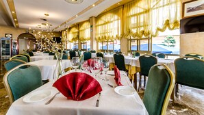 A restaurant with multiple tables, each set with white tablecloths, red napkins, and clear glassware. - Hotel Mediterraneo (Guardamar del Segura)