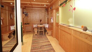 Un interior de madera con un banco, una mesa y una ventana decorada.