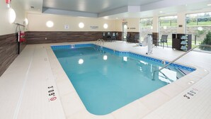 Une piscine intérieure avec des lignes de démarcation bien visibles, un poste de surveillance pour le sauveteur et un panneau indiquant qu’il est interdit de plonger.