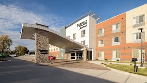 Un hôtel Marriott de Fairfield au design moderne, avec une façade en pierre et une entrée couverte.
