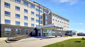 A modern hotel with a large entrance, multiple windows, and a covered area with a glass facade. - Four Points by Sheraton Houston Intercontinental Airport (Houston)