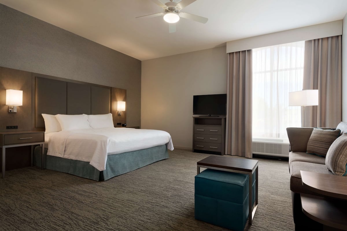 Une chambre d’hôtel avec un grand lit, une télévision, un bureau et un canapé.