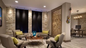 Un salon moderne avec un mur d’accent en pierre, une table basse ronde et des sièges confortables.