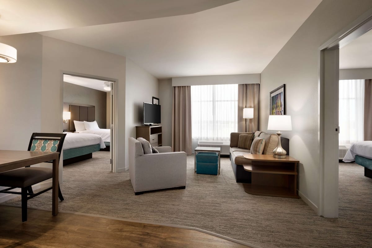 Une chambre d’hôtel moderne équipée d’un grand lit, d’un canapé, d’une table à manger et d’un téléviseur.