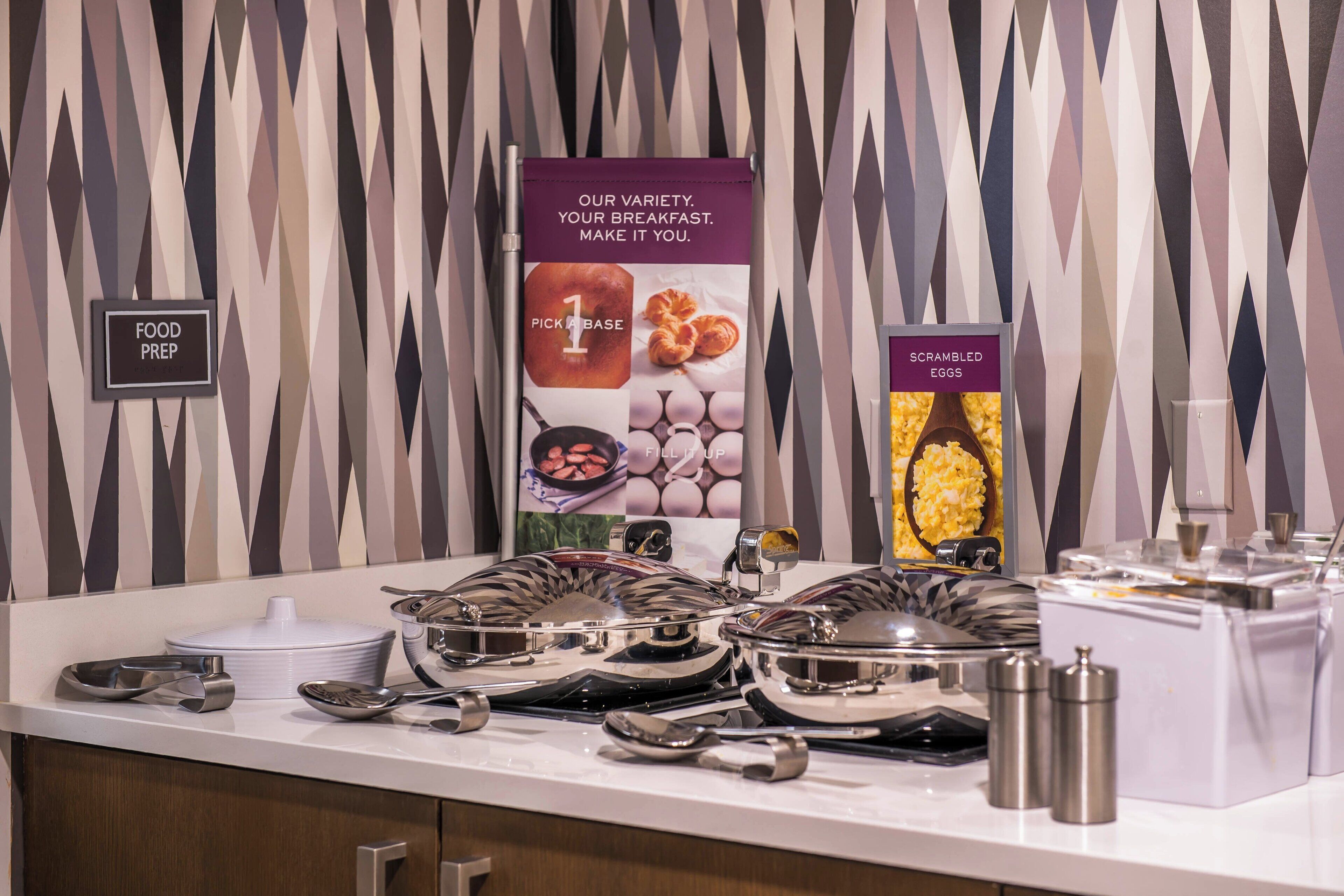 A buffet setup with various food items and serving utensils.