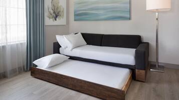 Una camera moderna con una divano letto, una lampada da terra e opere d'arte alle pareti.