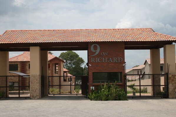 Una entrada con portón y un letrero que dice "9 on Richard".
