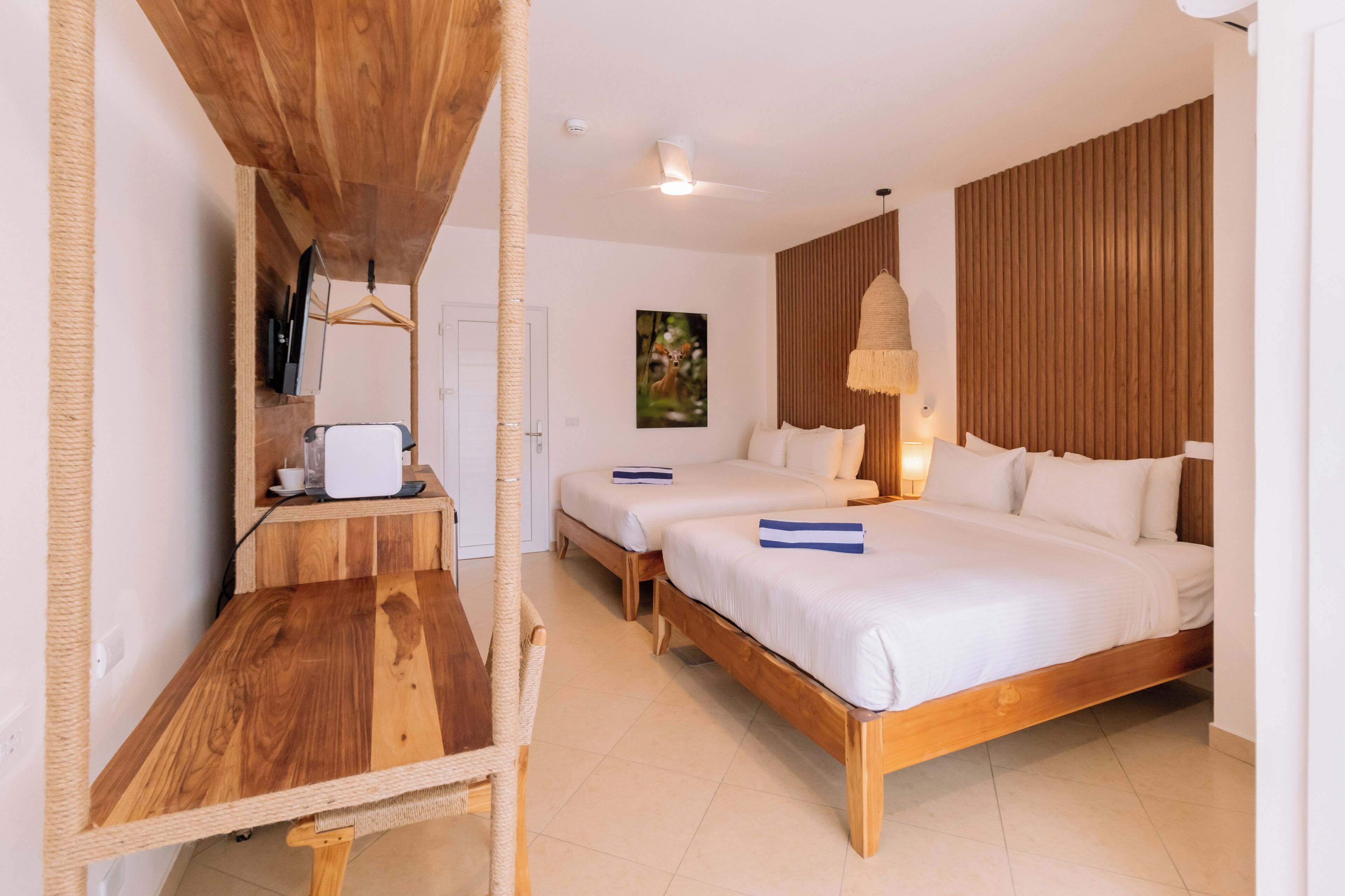 Una habitación de hotel con una cama de madera, un escritorio pequeño y una silla colgante.