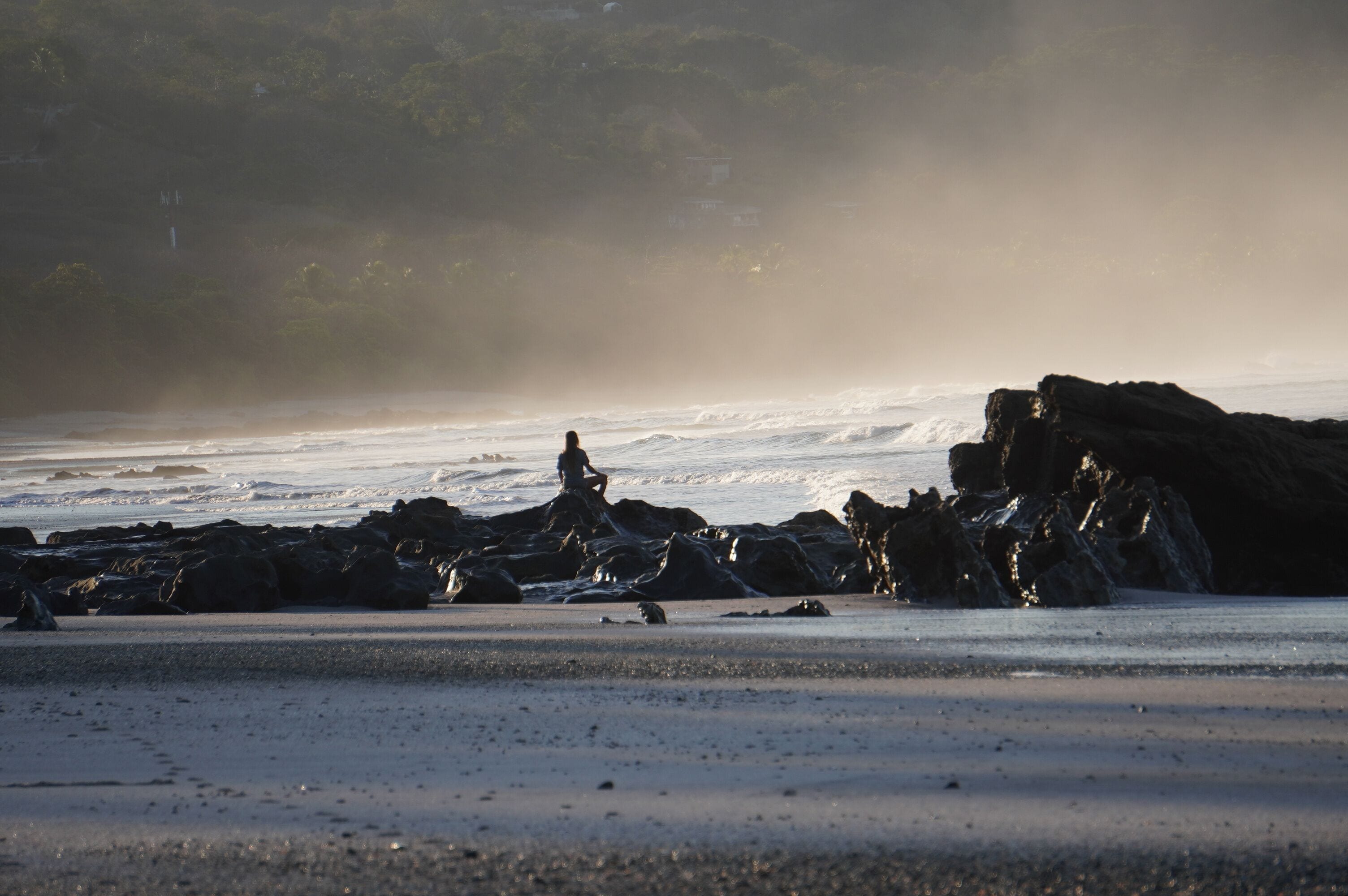 A beach with rocky formations and waves.