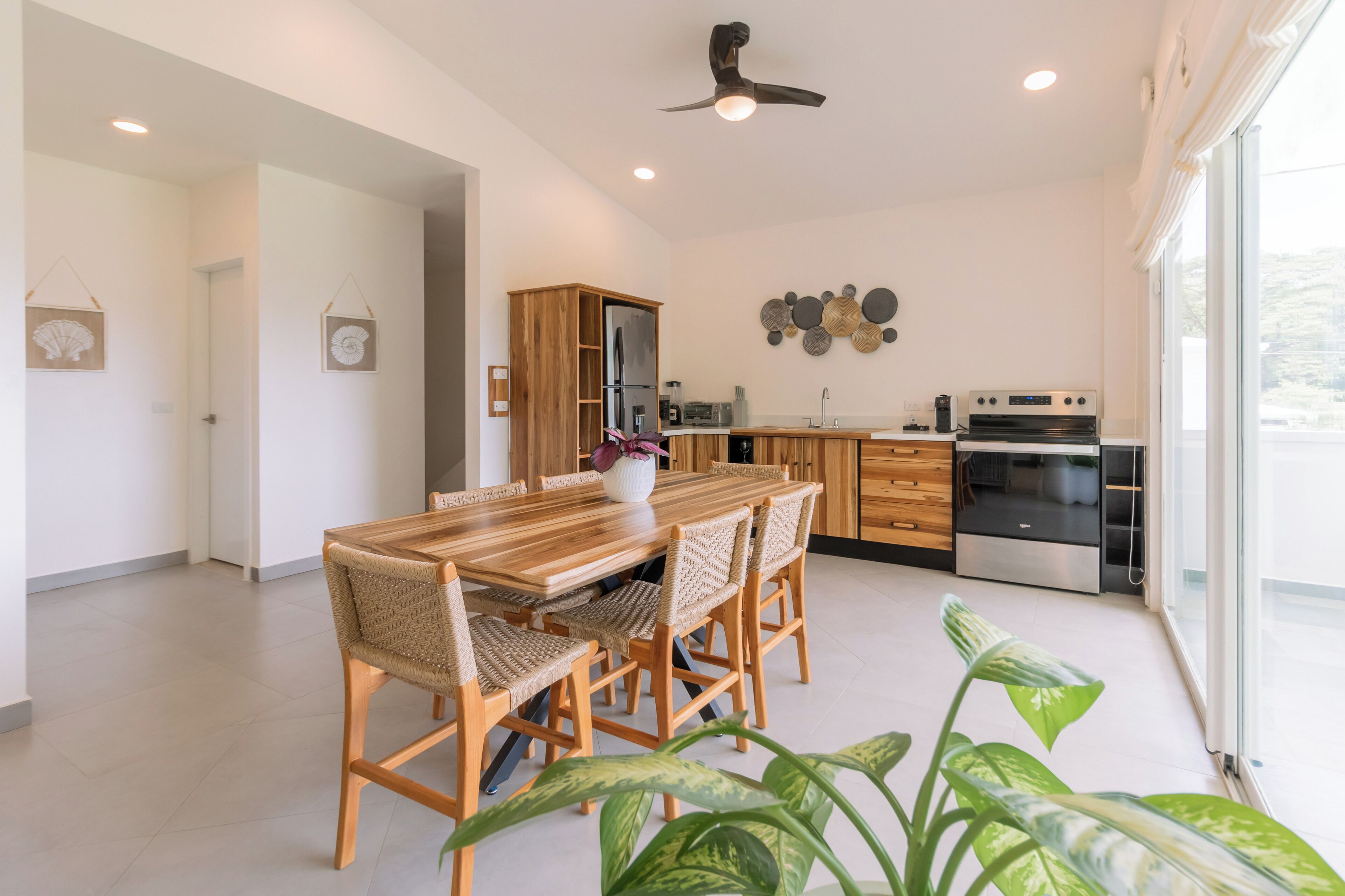 Una cocina moderna con una mesa y sillas de madera, un refrigerador y un horno.
