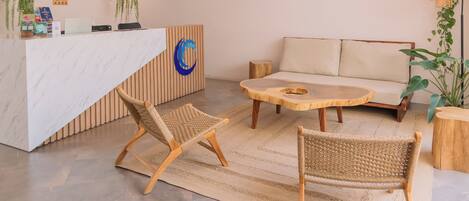 A modern reception area with a marble counter, wooden reception desk, and a sofa.