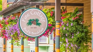 A sign for Pine Cottage Bed & Breakfast with a date of establishment 1870.
