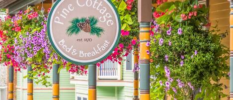 A sign for Pine Cottage Bed & Breakfast with a date of establishment 1870.