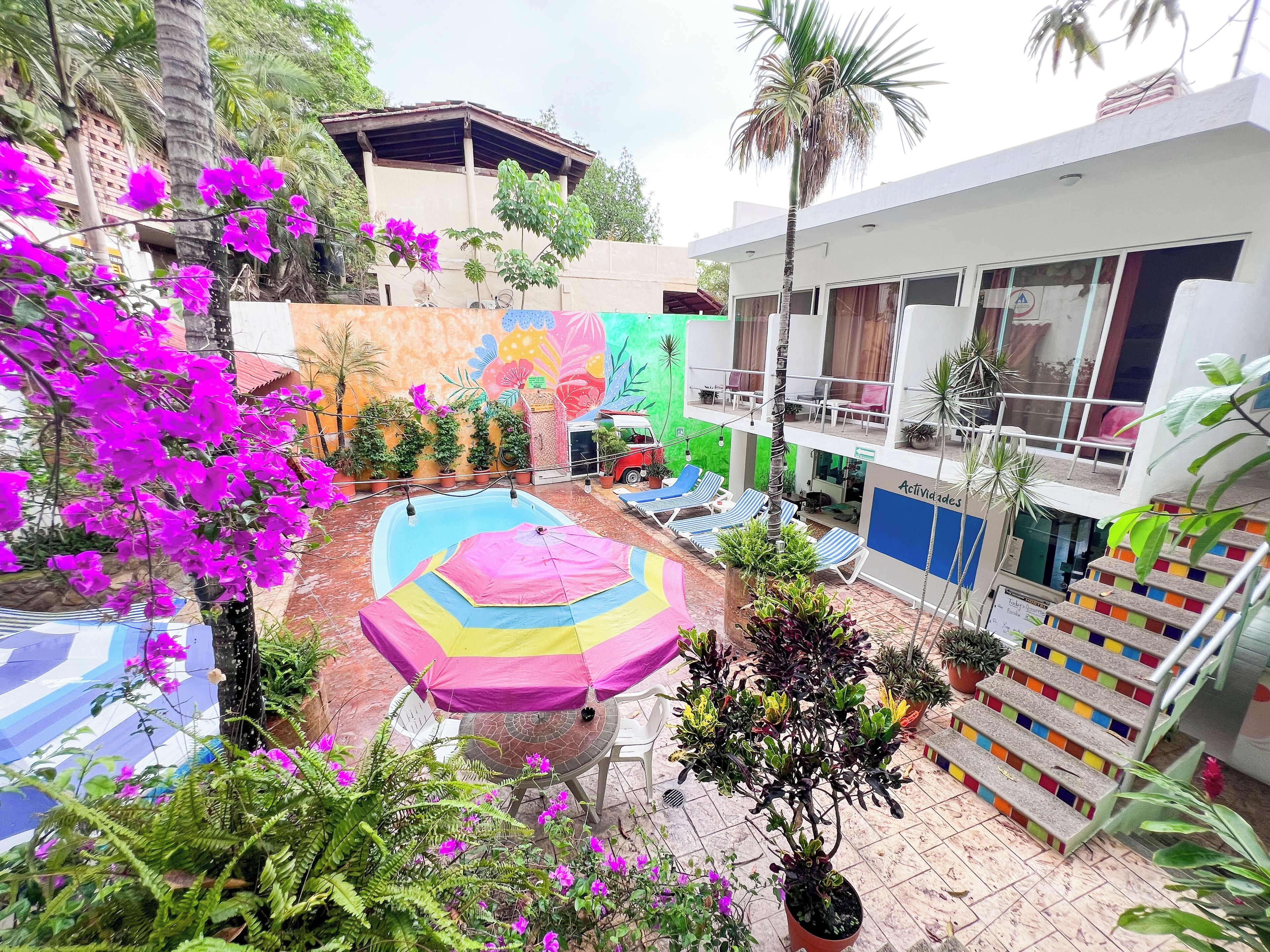 Un patio con piscina, sillones de descanso y plantas en macetas.