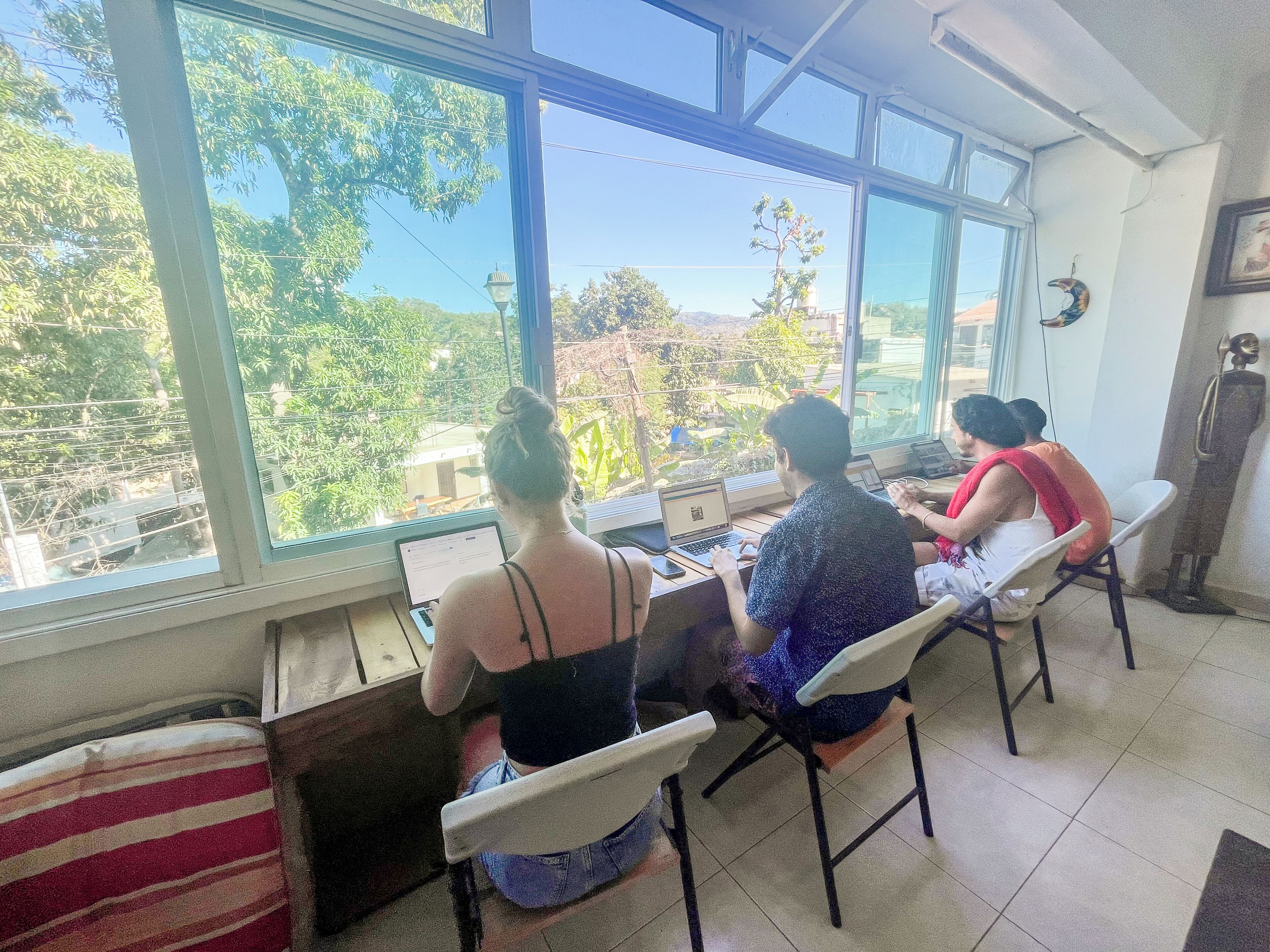 A room with large windows, a tiled floor, and a few chairs.