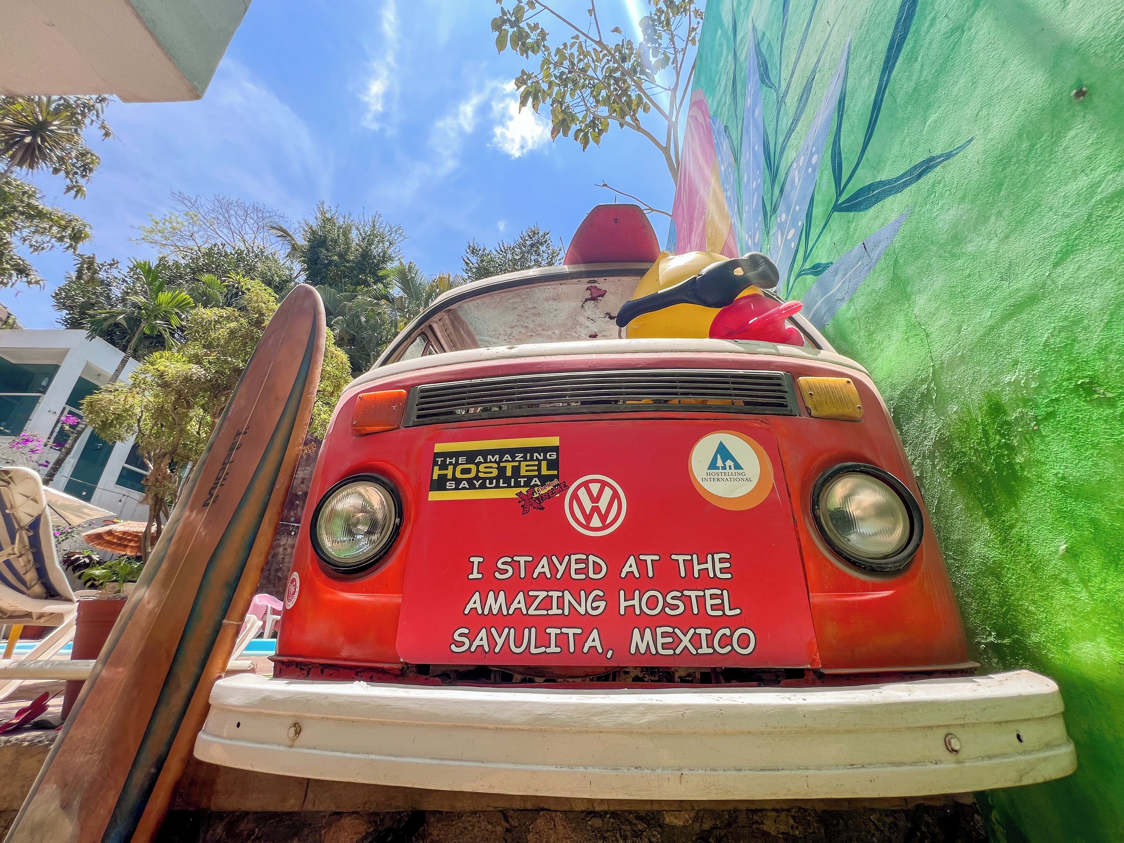 A red van with "The Amazing Hostel Sayulita, Mexico" written on it.