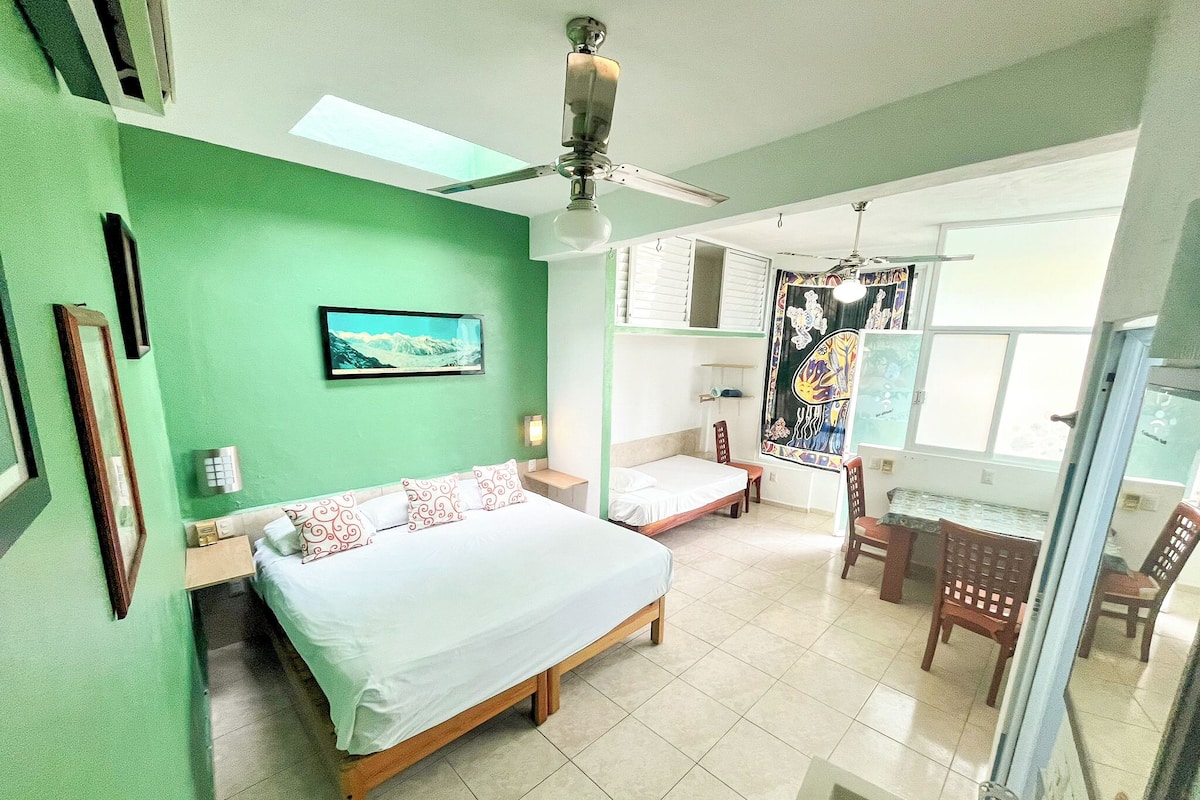 A bedroom with a bed, a desk, and a chair.